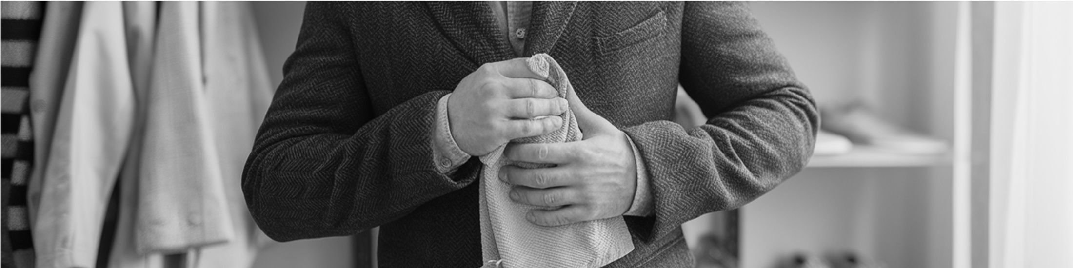 A man trying to rub a mark out of his jacket sleeve