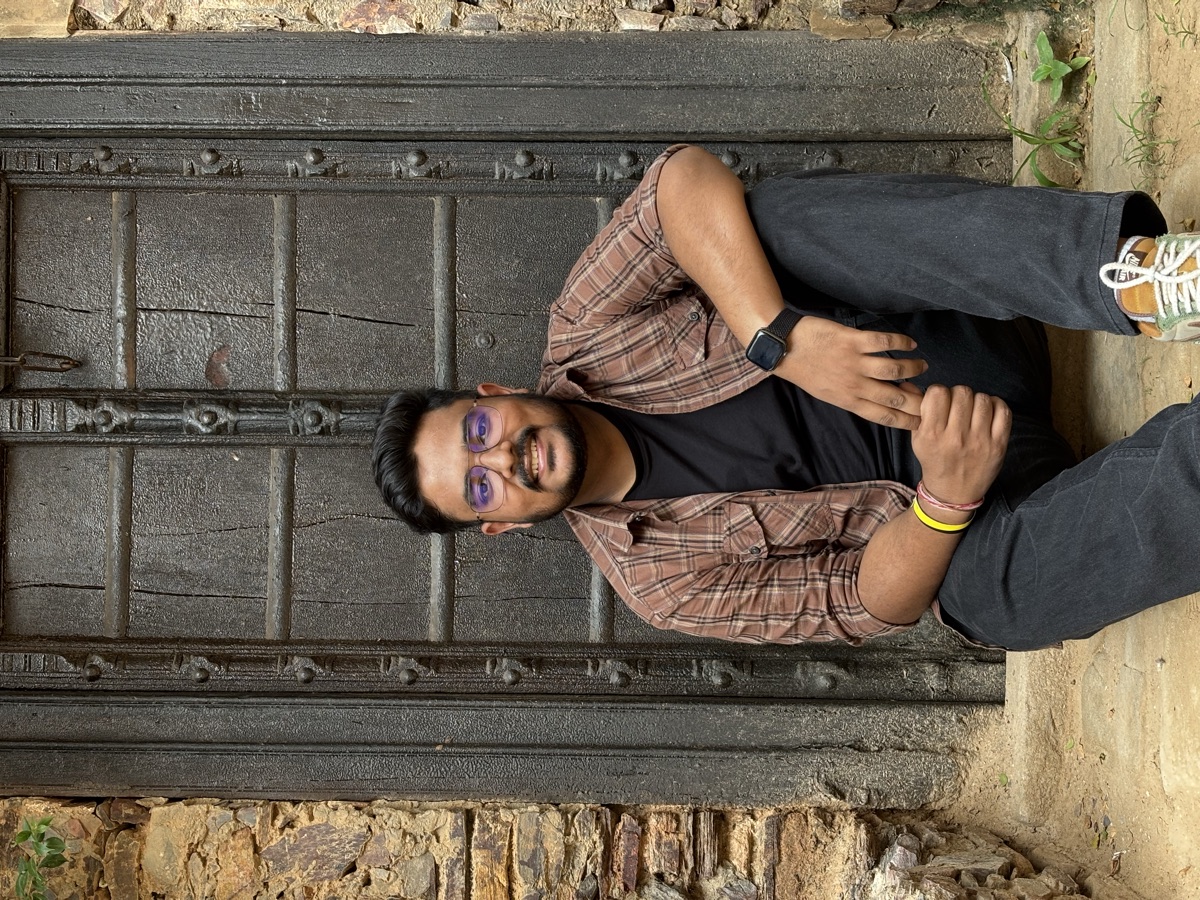 Kushal Kumar sitting at an old wooden doorway